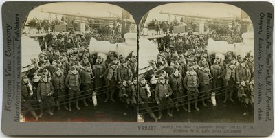 Horizontal, Sepia Stereocard Showing Uniformed American Soldiers Wearing Life Vests Standing and Sitting on the Deck of a Ship. Keystone Stereograph Number V19217. The Title Reads by Keystone View Company